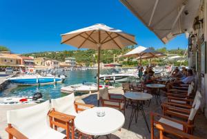 a restaurant with tables and chairs and a body of water at Spiros Jetty House in Longós