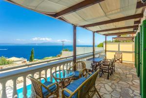 a balcony with chairs and tables and a view of the ocean at Villa Anastasia in Ieromónachos