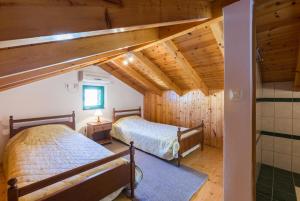 two beds in a room with wooden ceilings at Villa Anastasia in Ieromónachos