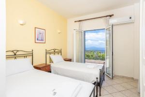 two beds in a room with a window at Villa Youla in Nisaki +29 photos