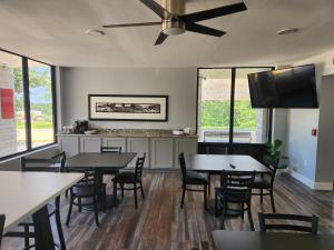 a dining room with tables and chairs and a flat screen tv at Heritage Place Hotel in Iuka