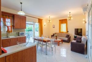 cocina y sala de estar con mesa y sofá en Villa Mary, en Gerani