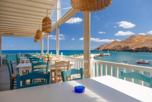 un restaurante con mesas y sillas y vistas al océano en Villa Mary, en Gerani