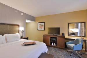 a hotel room with a bed and a television at Hampton Inn & Suites Chippewa Falls in Chippewa Falls