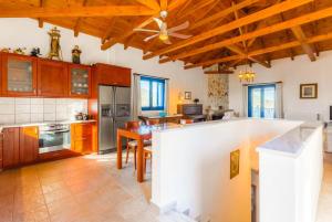 cocina grande con techo de madera y ventilador de techo en Villa Levanda, en Panormos Skopelos