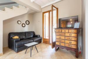 a living room with a black leather couch and a dresser at Villa Neria in Áptera