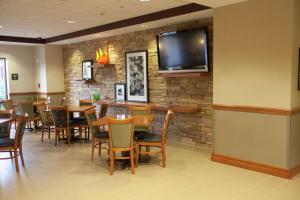 a restaurant with tables and chairs and a tv on a brick wall at Hampton Inn Elmira/Horseheads in Horseheads