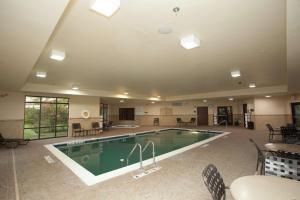 uma grande piscina numa sala com mesas e cadeiras em Hampton Inn Elmira/Horseheads em Horseheads