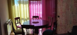 a table and chairs in a room with pink curtains at Appartamento di Anna in La Spezia