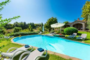 - une piscine avec des chaises et un parasol dans l'établissement Villa Casale Silvia, à Terni