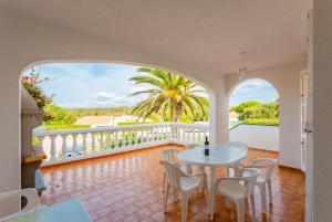 a room with a balcony with a table and chairs at Villa Bini Estrella in Es Canutells