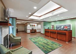 a lobby with a fireplace and green walls at Hampton Inn & Suites El Paso West in El Paso