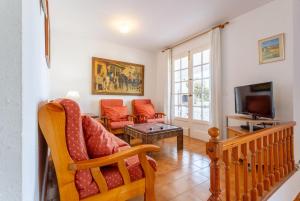ein Wohnzimmer mit einem Sofa und einem TV in der Unterkunft Villa Bini Estrella in Es Canutells