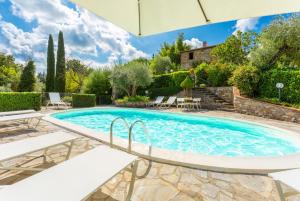 een zwembad in een tuin met stoelen en een parasol bij Villa Caporlese in Terni