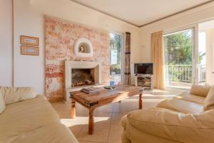 a living room with a table and a fireplace at Villa Pelagos in Agia Triada