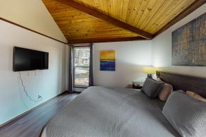 a bedroom with a bed and a flat screen tv at Aspen Butte Beauty in Sunriver +34 photos