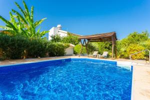 a pool with a gazebo next to a house at Villa Charoula Pente in Paphos