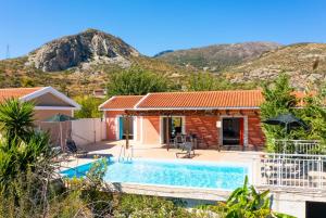 a house with a swimming pool and mountains in the background at Villa Cherry in Plateies