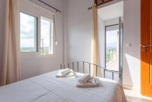 a bedroom with a bed with two towels and a window at Villa Giannis in Áyios Andónios +30 photos