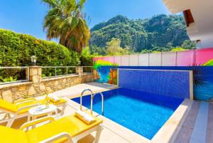 a villa with a swimming pool with mountains in the background at Villa Aysel Paradise in Mugla