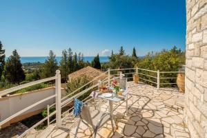 a patio with a table and chairs on a balcony at Villa Windmill in Vlachopoulátika