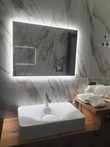 ein Badezimmer mit einem weißen Waschbecken und einem Spiegel in der Unterkunft LUXURY HOLIDAY HOUSE in Diamante