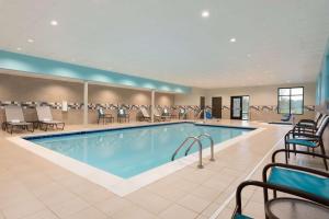 a pool in a hotel lobby with chairs and tables at Hampton Inn & Suites Kenosha in Kenosha