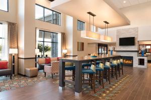 a lobby with a bar with chairs and a fireplace at Hampton Inn & Suites Kenosha in Kenosha