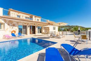 a villa with a swimming pool and blue chairs at Villa Christel in Lachi