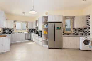 a kitchen with a refrigerator and a washer and dryer at Villa Christel in Lachi