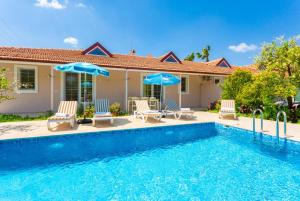 a house with a swimming pool with chairs and umbrellas at Villa Duman 3 in Dalyan