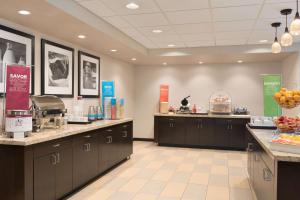 a large kitchen with brown cabinets and fruits on the counter at Hampton Inn & Suites Kenosha in Kenosha