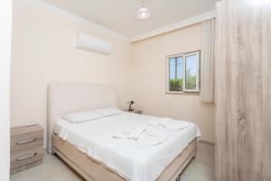 a white bedroom with a bed and a window at Villa Duman 3 in Dalyan +34 photos