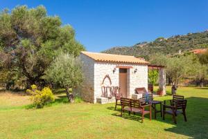 uma pequena casa com uma mesa e cadeiras num quintal em Villa Eufrosini em Svoronata