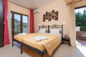 a bedroom with a large bed and a balcony at Villa Eufrosini in Svoronata
