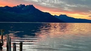 a sunset over a lake with mountains in the background at Norwegian Dream in Gratangen