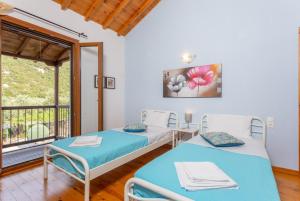 2 łóżka w pokoju z balkonem w obiekcie Villa Glysteri w mieście Panormos
