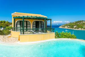 a villa with a swimming pool in front of the ocean at Thanasis in Dalietátika