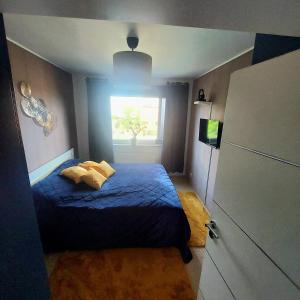 a small bedroom with a blue bed and a window at Private Apartment Laatzen City in Hannover