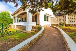 a white house with a walkway in front of it at Villa Trepuco Uno in Punta Prima