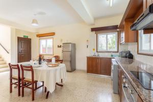 a kitchen with a table and chairs in a kitchen at Argaka Sun Villa Ena in Argaka