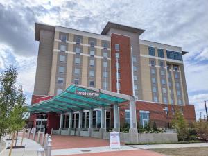 um edifício de hotel com um sinal de boas-vindas em frente em Hampton Inn & Suites Erie Bayfront em Erie