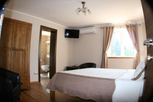 a bedroom with a bed and a bathroom with a window at B&B Millenium House in Plitvička Jezera