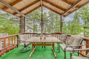 a wooden table and chairs on a deck at Charming Cloudcroft Retreat with Fire Pit! in Cloudcroft