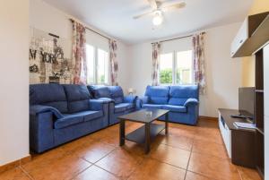 uma sala de estar com um sofá azul e uma mesa em Villa La Luna em Cala en Blanes