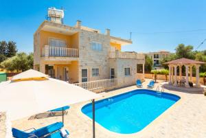 a villa with a swimming pool and an umbrella at Villa Prodromi in Prodhromi