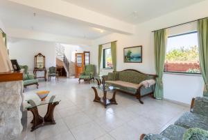 sala de estar con muebles y ventana grande en Villa Olivetta, en Kato Yialia