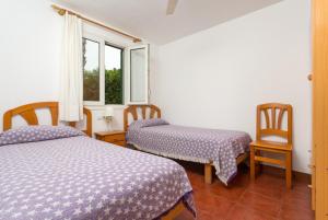 a bedroom with two beds and a window at Villa Calitja Dos in Cala'n Bosch +27 photos