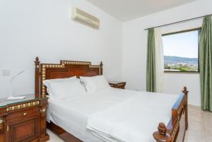 a bedroom with a large bed and a window at Villa Olivetta in Kato Yialia