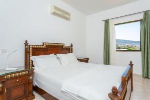 Un dormitorio con una cama grande y una ventana. en Villa Olivetta, en Kato Yialia 54 fotos más